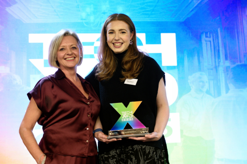 Abigail Simpson, founder of Evex Digital Health, smiling on stage while holding the Best Elevator Pitch award, standing to the right of SETsquared Bristol Centre Manager Caroline Thompson at Tech-Xpo 2025 in Bristol.